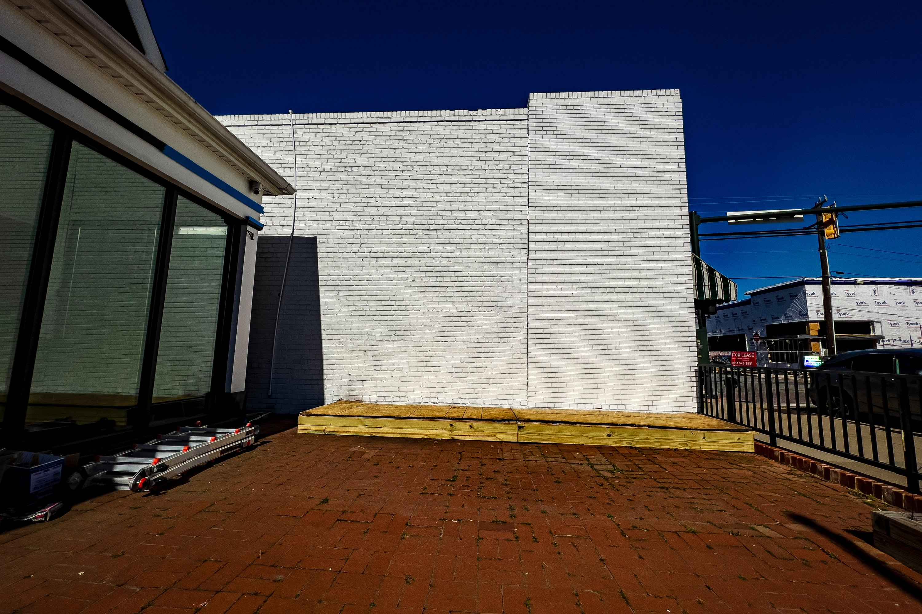 The wall cleaned and primed white at dusk, the platform still in place along its base