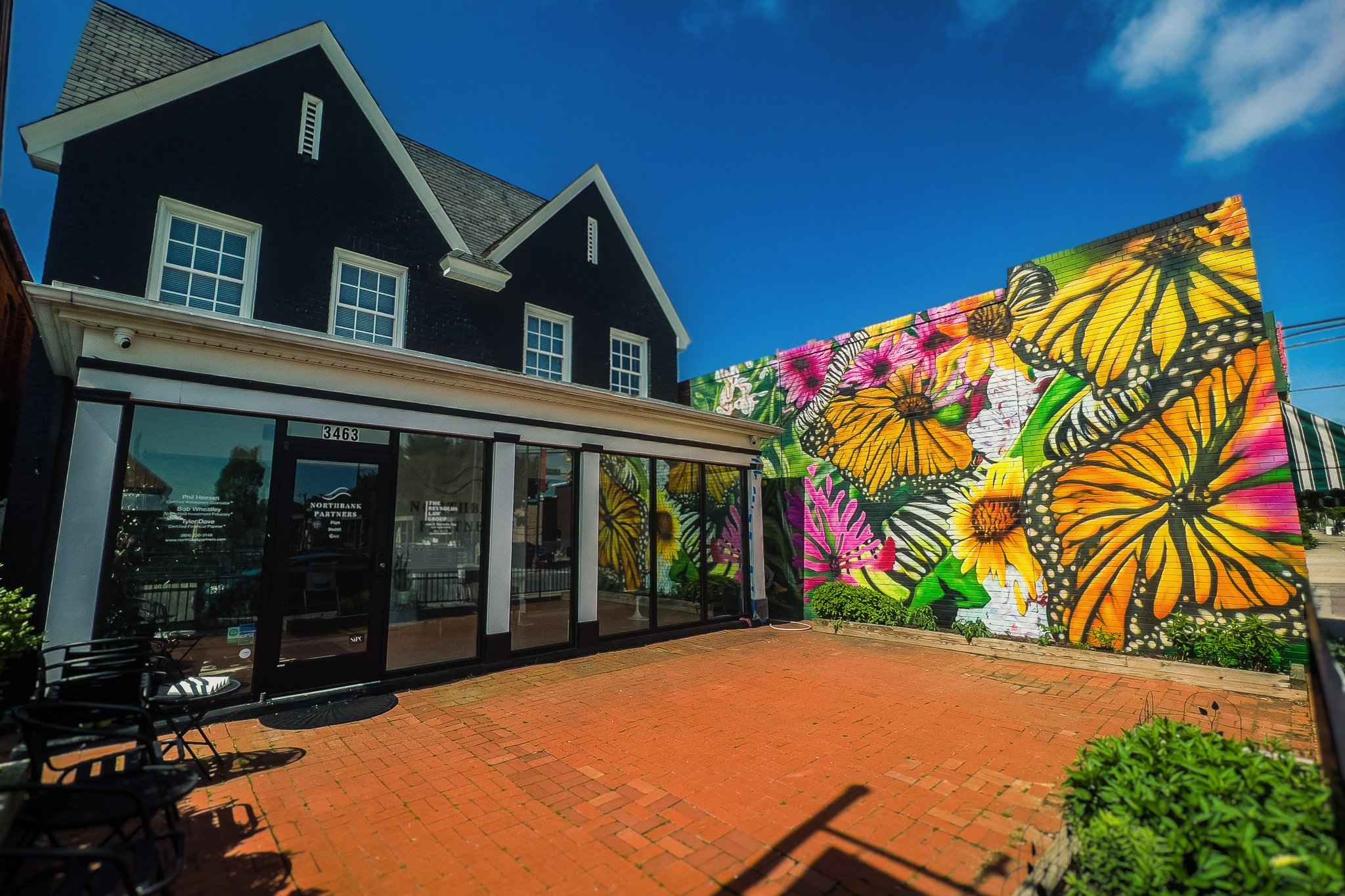 The mural from the brick patio, the Northbank storefront along the left and the painted wall closing the far end