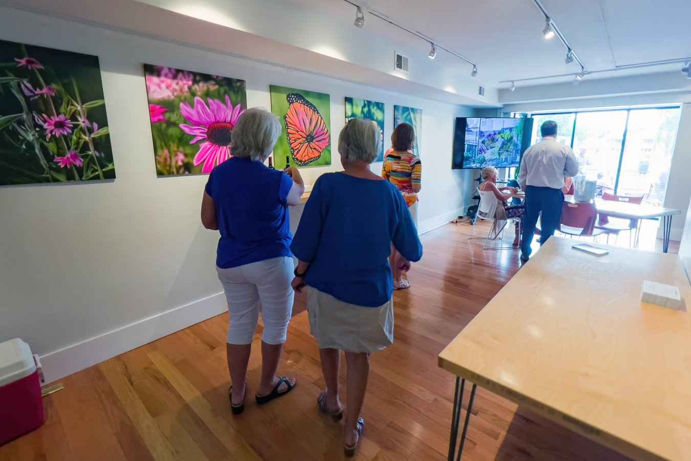 Clients looking at the printed reference images along the office wall on opening day