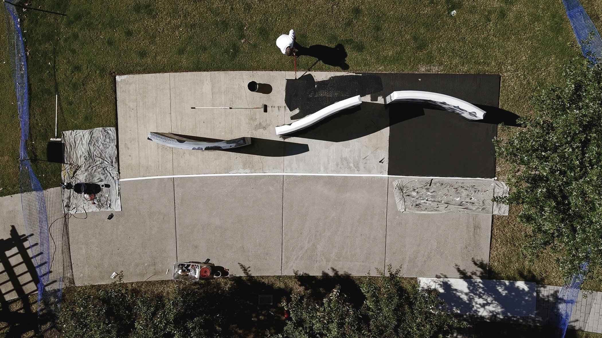 The concrete slab between the walls being painted black, seen from above, the three walls finished around it
